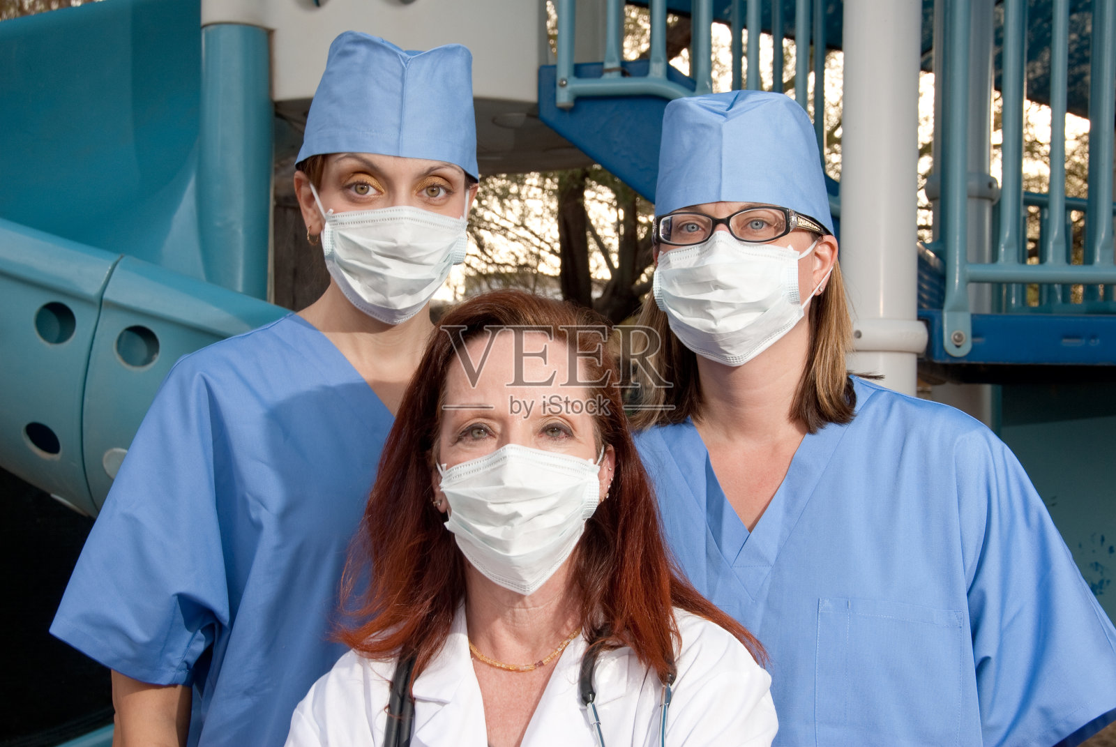 医生和两个护士站在操场前照片摄影图片