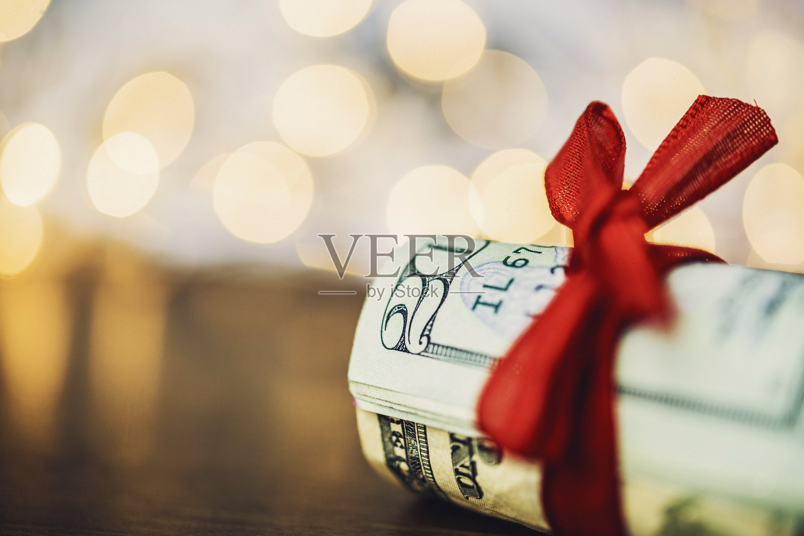 圣诞节的现金。一捆用红丝带绑着的美元照片摄影图片