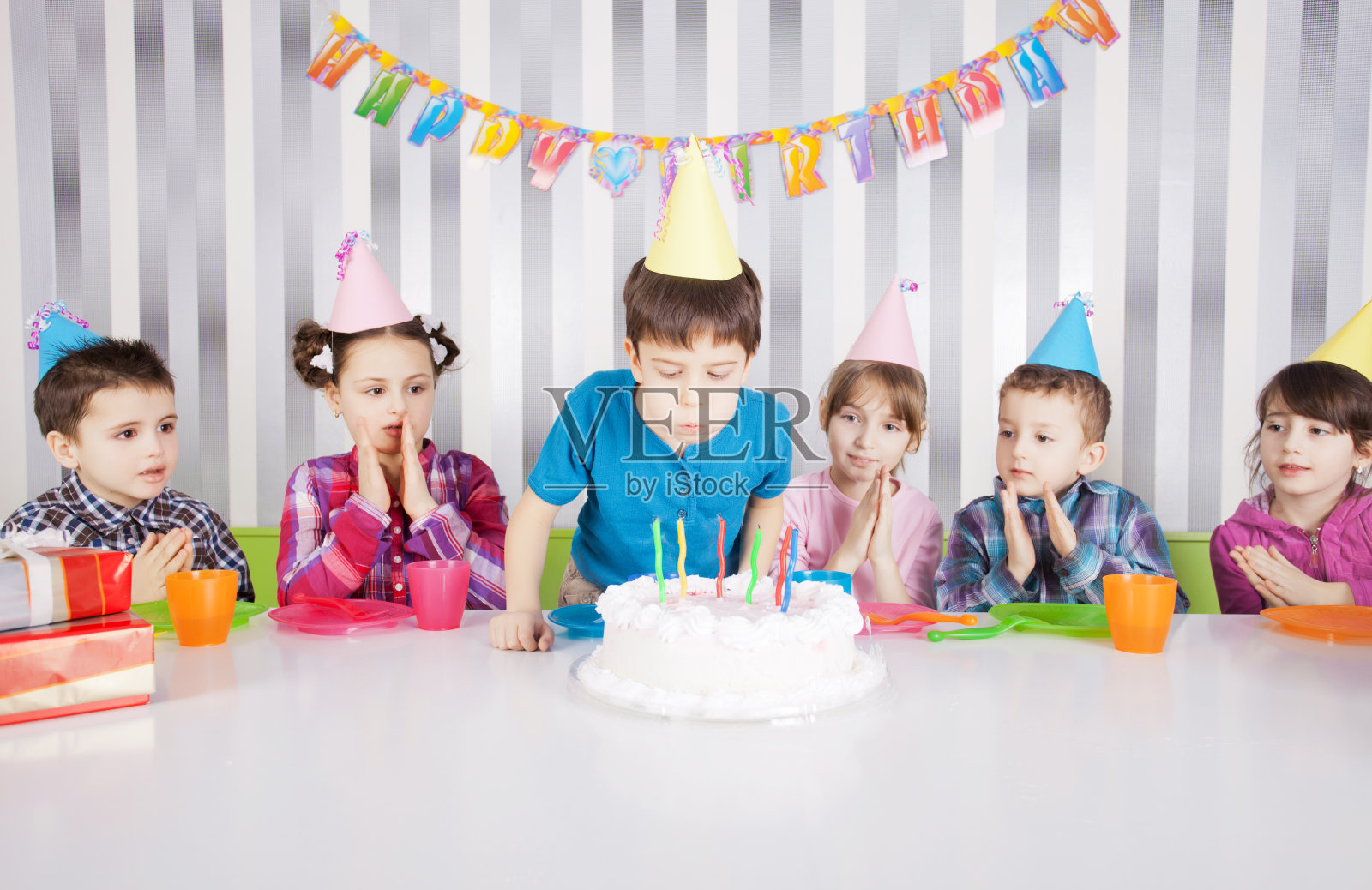孩子们在生日聚会上吹蜡烛在蛋糕上照片摄影图片_ID:100837952-Veer图库