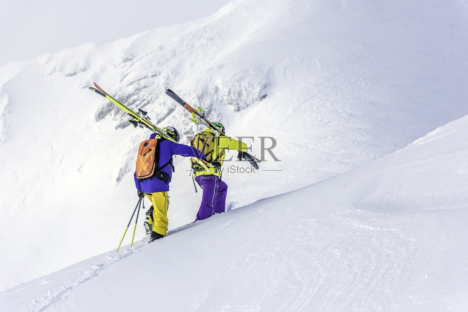 两个滑雪者爬上一座雪山照片摄影图片