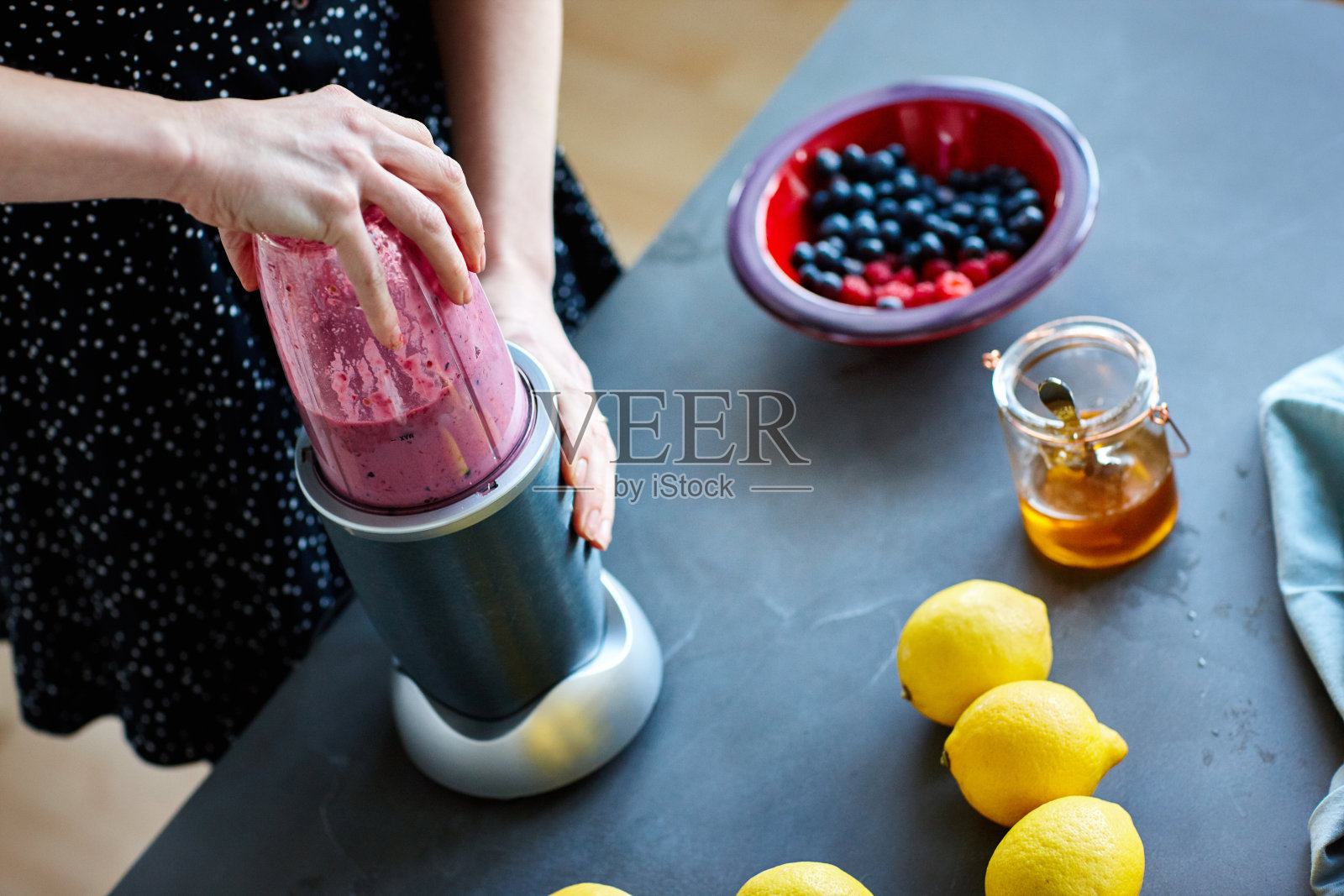 用榨汁机榨果汁的女人照片摄影图片