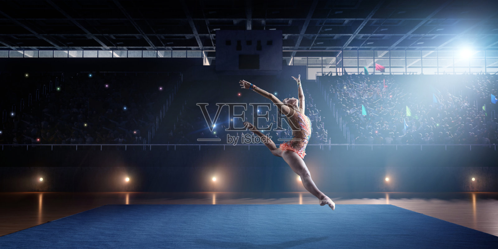 体操女运动员在大型专业舞台上跳跃照片摄影图片