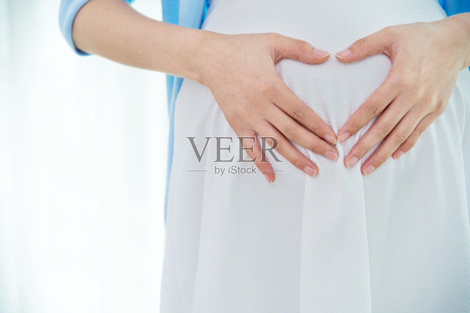 孕妇在肚子上摆心形造型照片摄影图片
