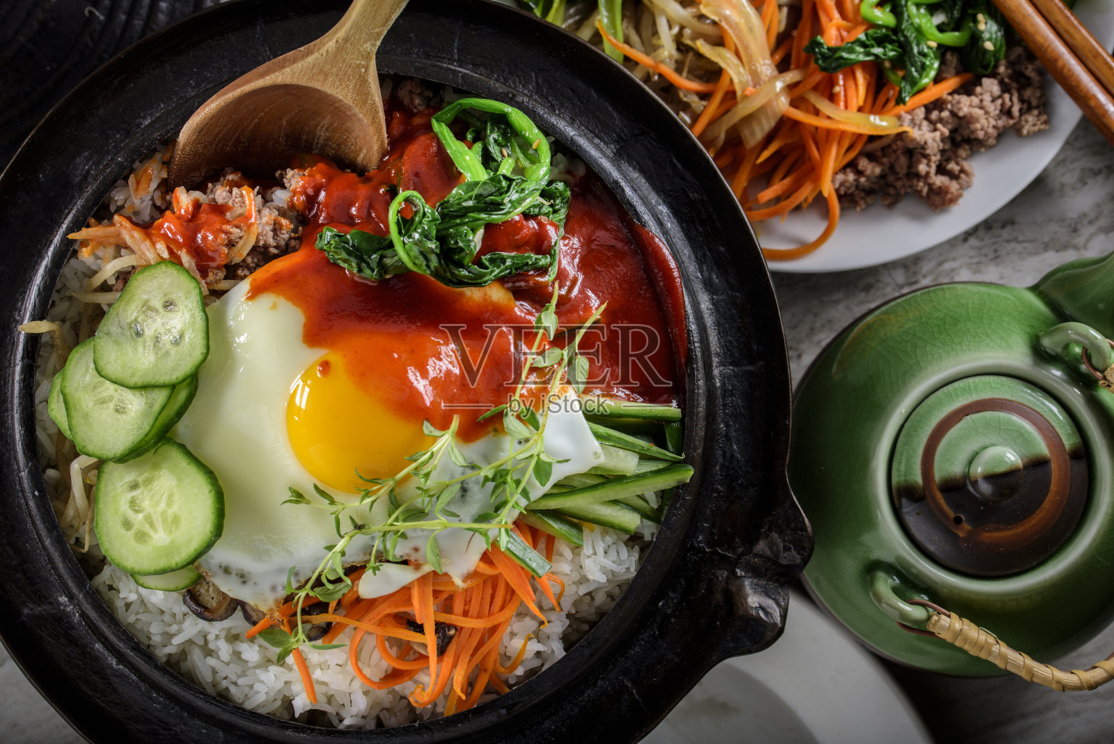 韩式石锅拌饭，拌菜饭，顶视图与热酱在铸铁锅照片摄影图片