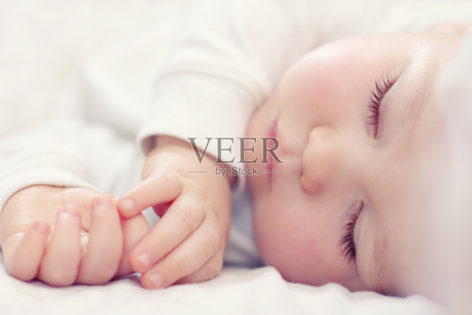 一个美丽的婴儿在白色上睡觉的特写照片摄影图片