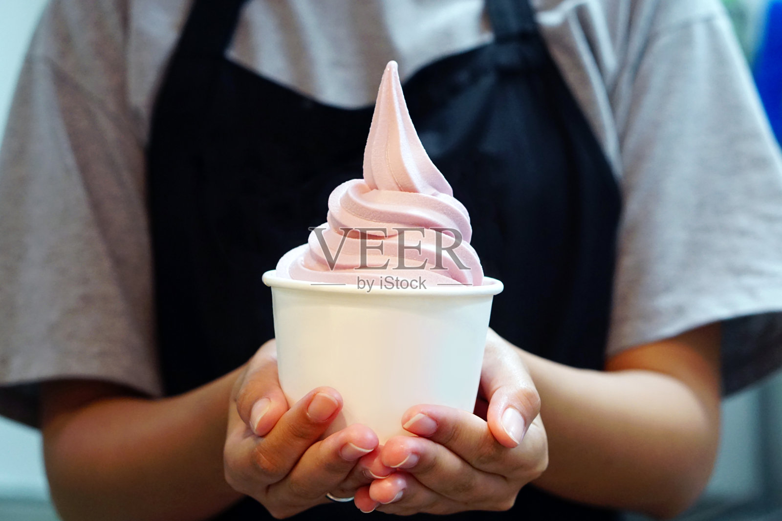 女人的手拿外卖杯与有机冻酸奶冰淇淋，这是美味和健康的享受吃的概念。照片摄影图片