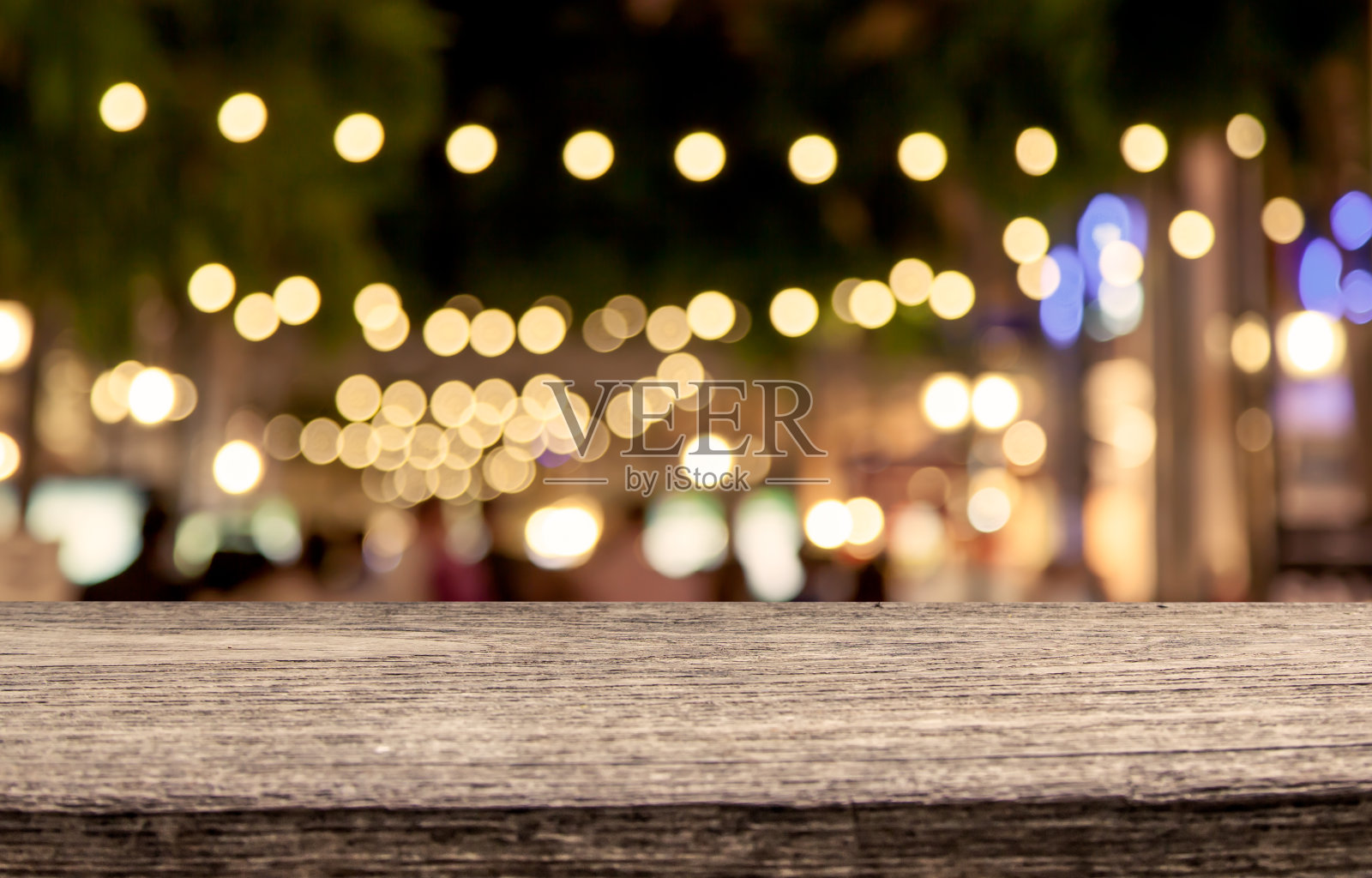 木桌与抽象的散景在夜间购物中心照片摄影图片