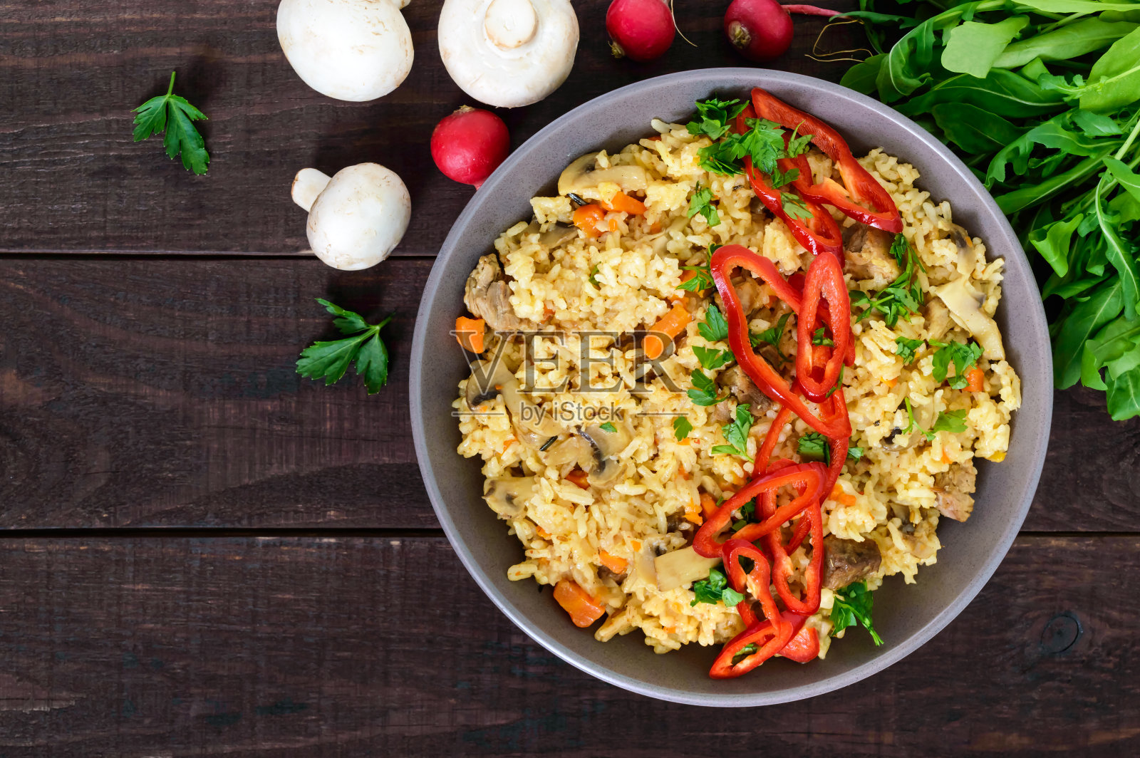 一种传统的亚洲菜-肉饭与肉，蘑菇和辣椒辣椒在一个碗在深色的木制背景。前视图。照片摄影图片