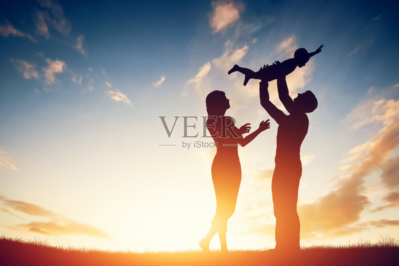 幸福的家庭在一起，父母和他们的孩子在日落。照片摄影图片