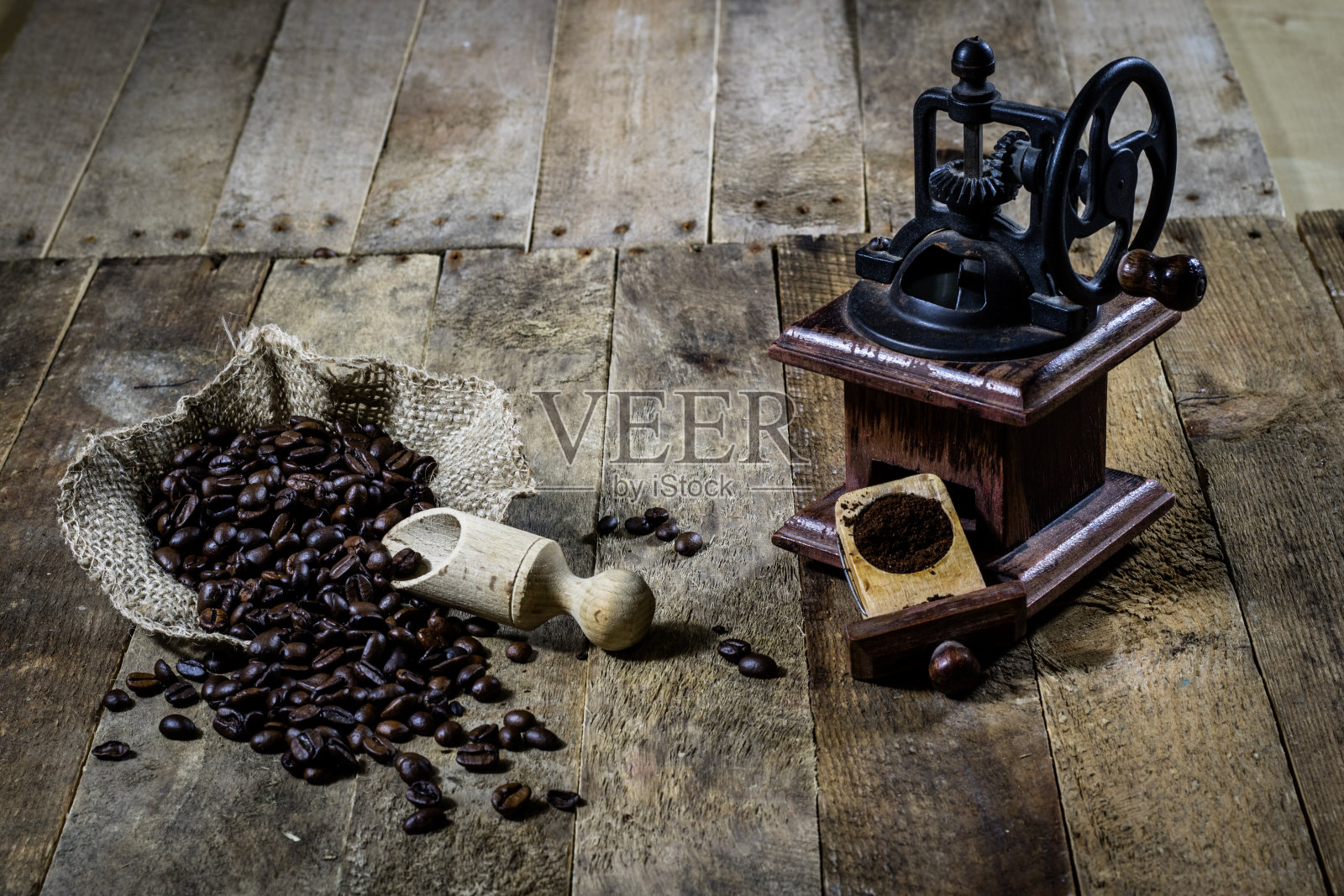 在旧木桌上研磨美味咖啡的老式时尚研磨机照片摄影图片