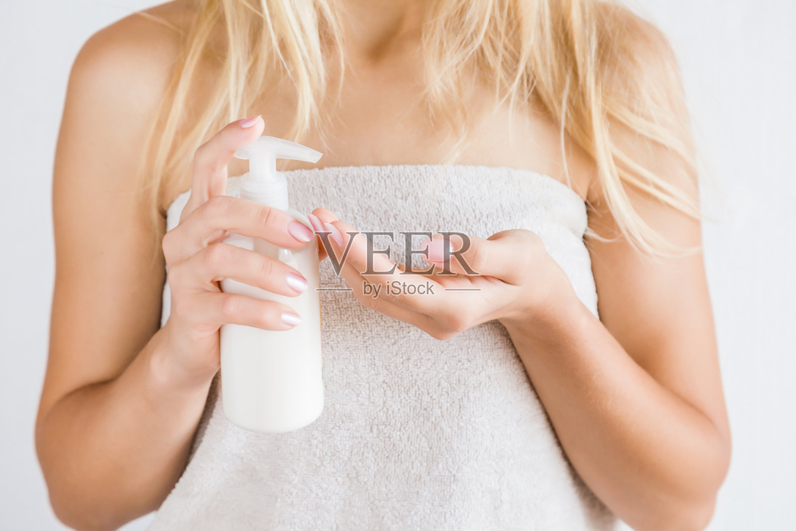 年轻女子沐浴后使用身体霜毛巾。皮肤护理。照片摄影图片
