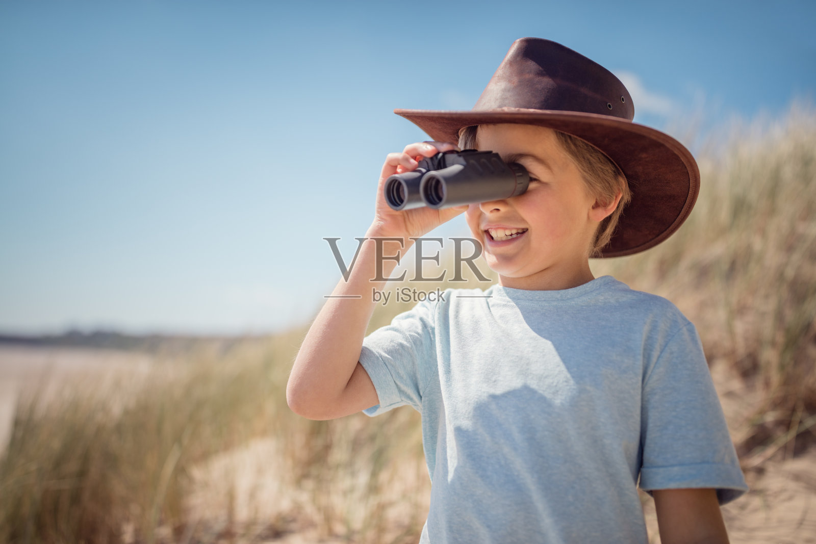 带着双筒望远镜的儿童探险家在海滩上照片摄影图片