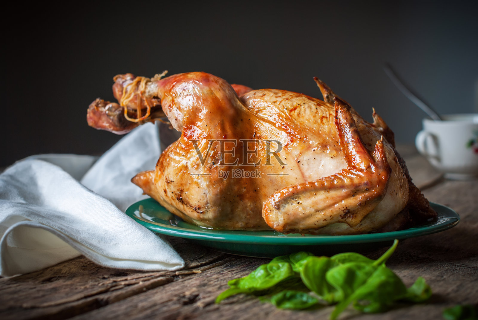 木桌上的烤鸡，灰色背景照片摄影图片