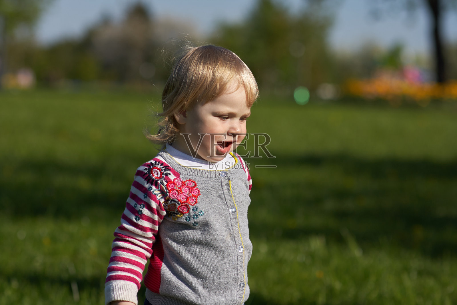 女孩坐在公园的草地上照片摄影图片