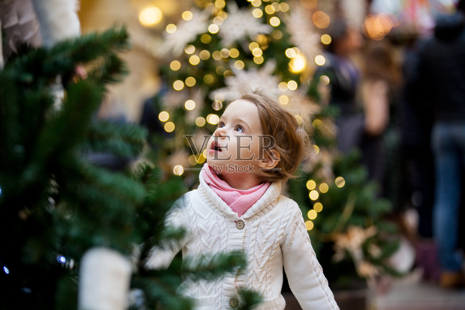 可爱的小女孩看着圣诞树照片摄影图片