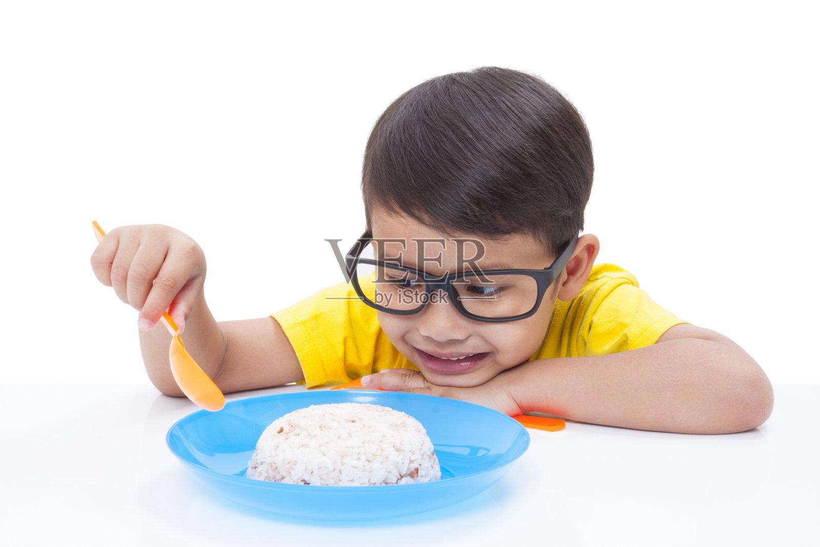 小男孩在吃米饭。照片摄影图片