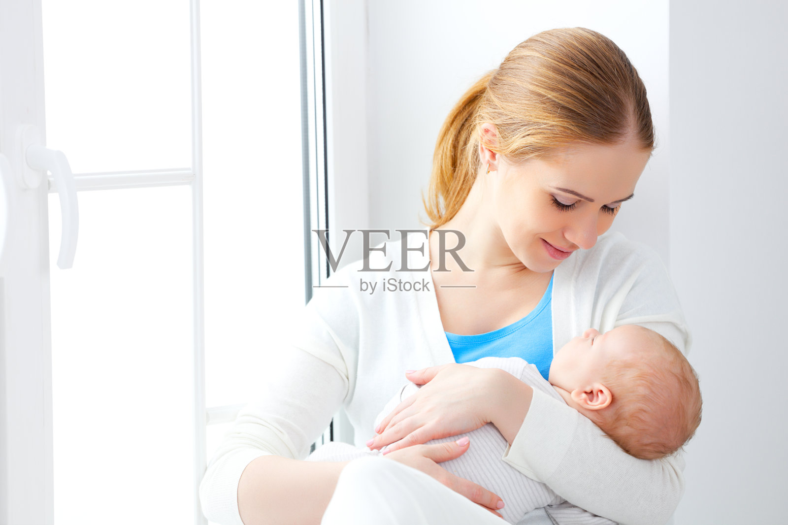 刚出生的婴儿在母亲温柔的怀抱中照片摄影图片