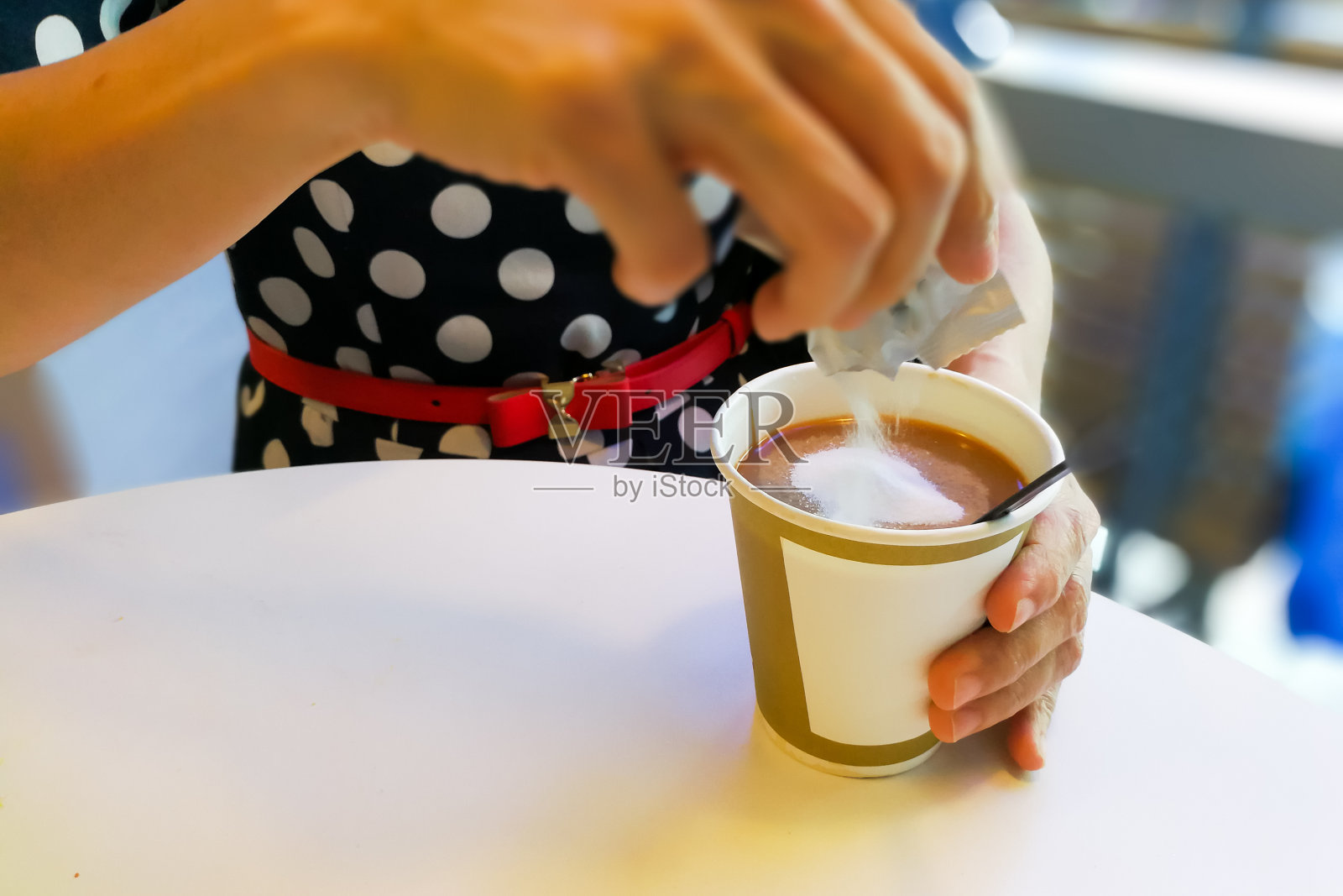 用手将不健康的非奶精从香包中倒入咖啡中照片摄影图片