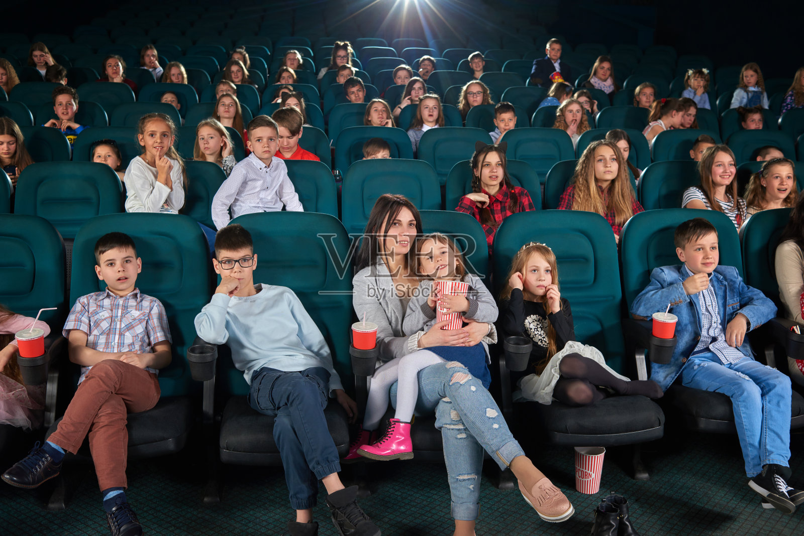 孩子们和父母一起在电影院看电影照片摄影图片