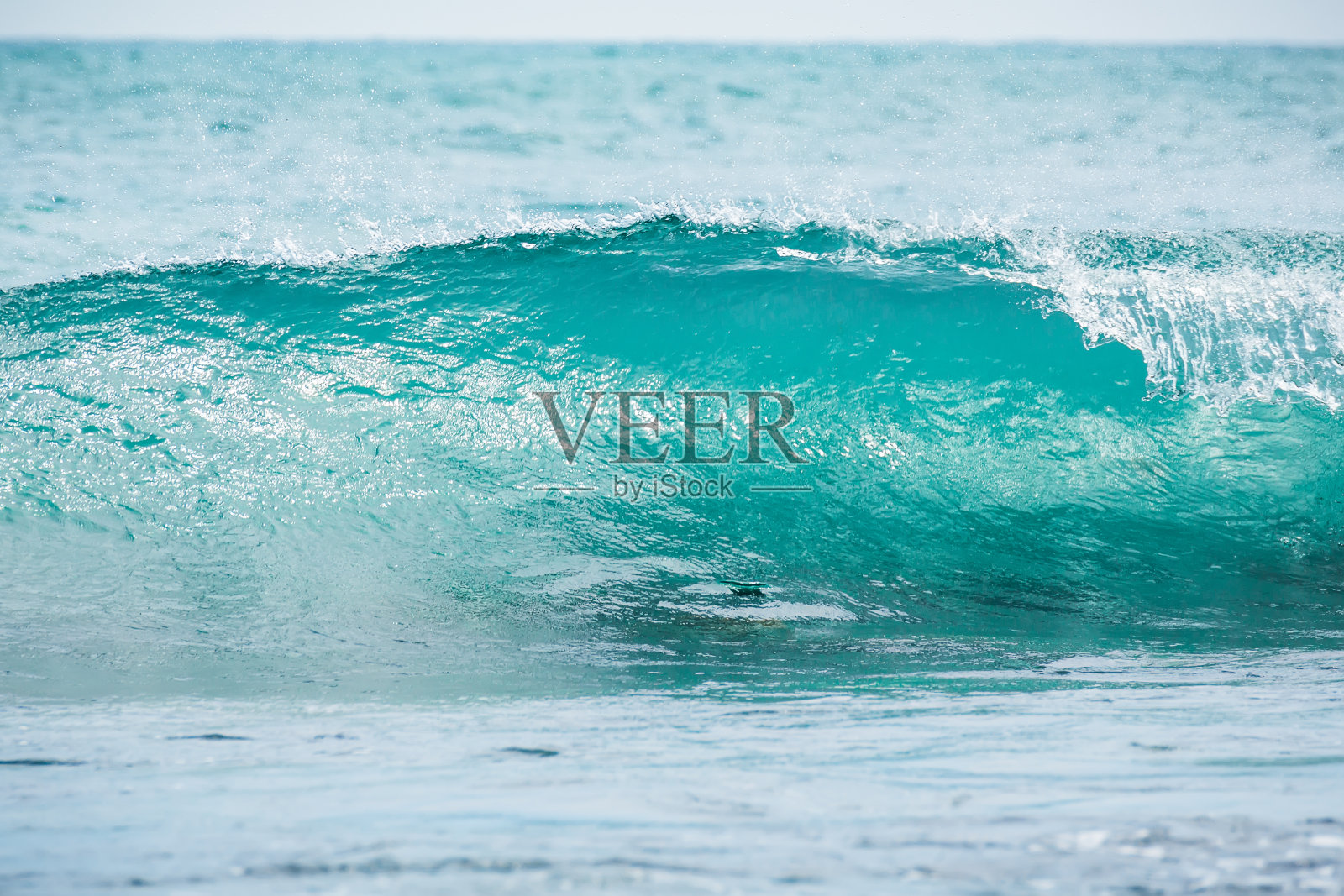 热带海洋中的蓝色桶波。海浪撞击和阳光。清水。照片摄影图片