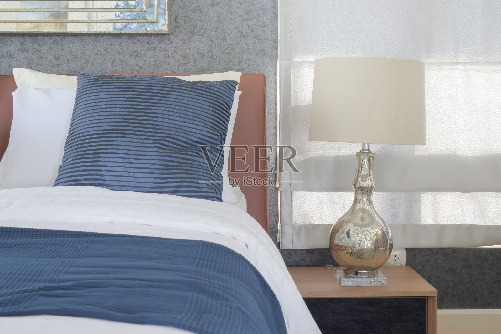 卧室里的蓝色床上用品和古典风格的白色台灯照片摄影图片