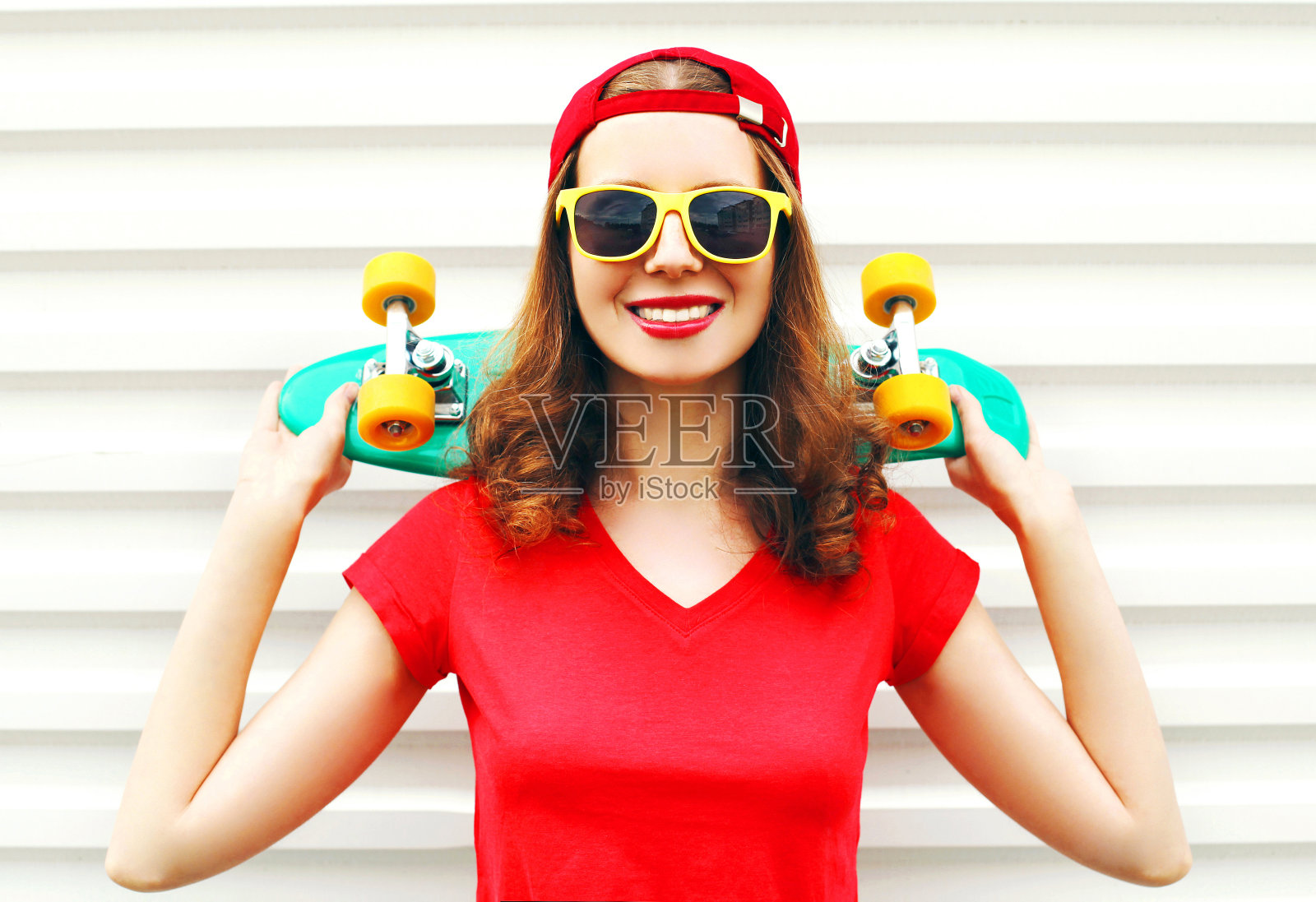 时尚肖像微笑的年轻女子与滑板在白色的背景照片摄影图片