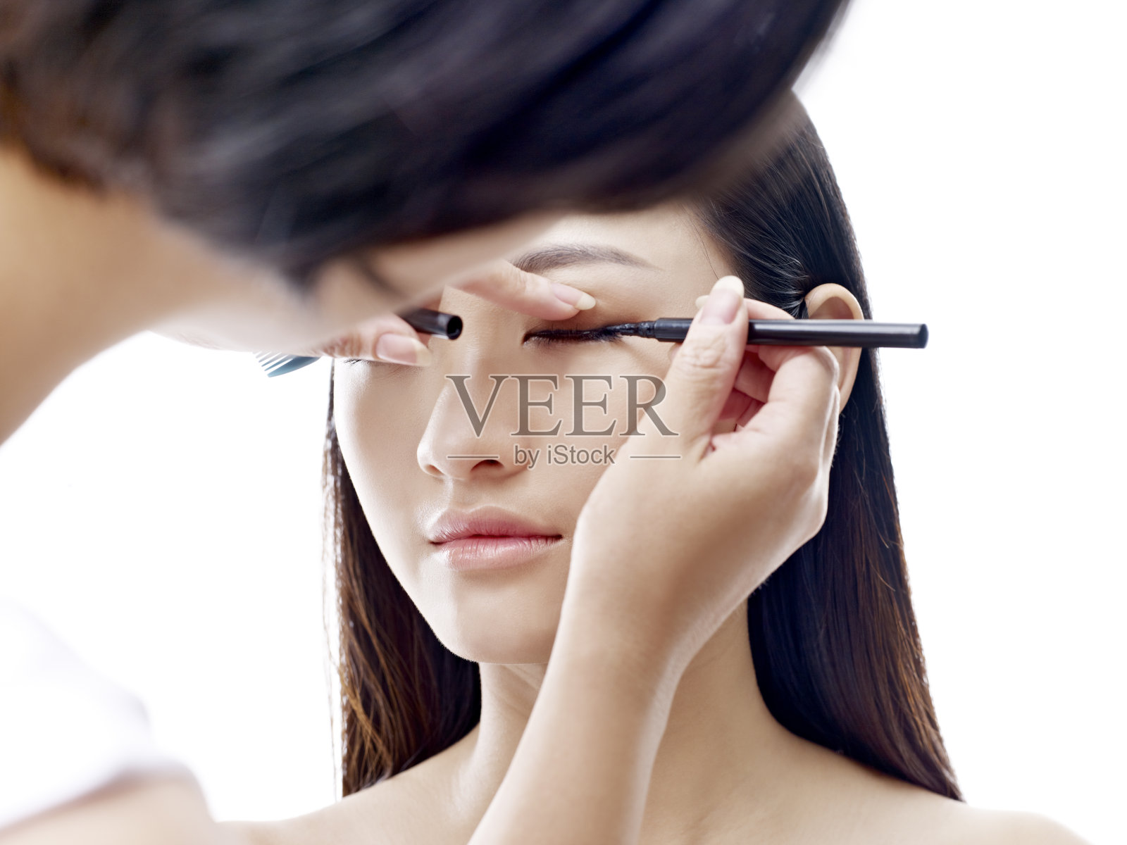 化妆师在一位亚洲女模特身上工作照片摄影图片