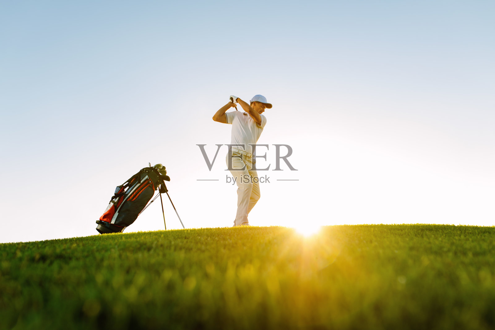 男高尔夫球手在高尔夫球场上击球照片摄影图片