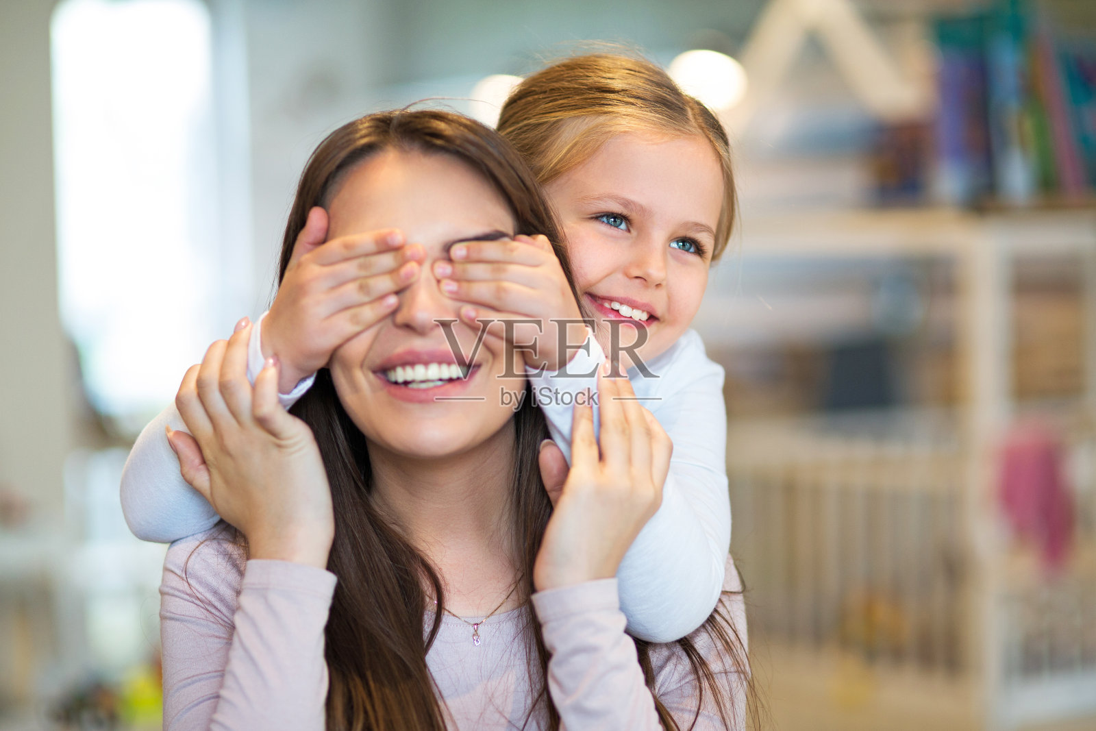 快乐的小女孩捂住妈妈的眼睛照片摄影图片