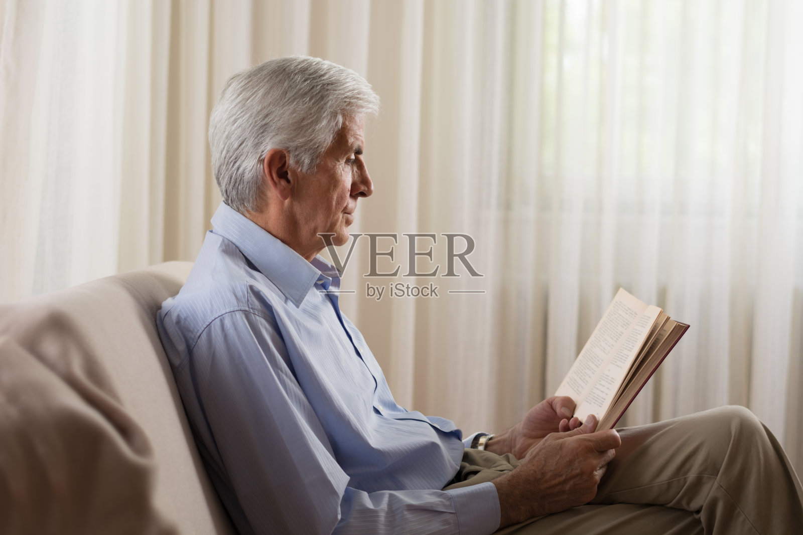 老人在家放松，看书照片摄影图片