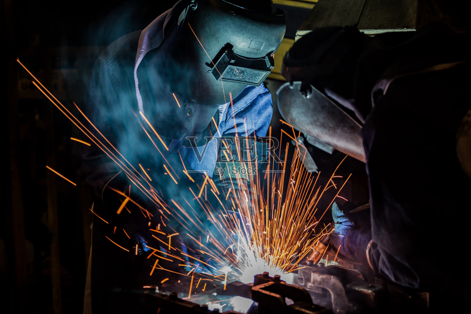 汽车厂的工人们正在焊接钢零件照片摄影图片
