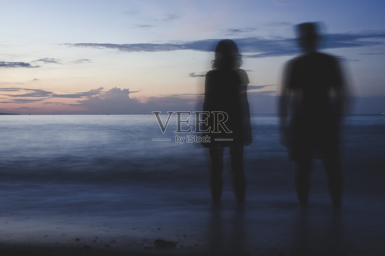 一对情侣在海滩上放松。印尼巴厘岛。照片摄影图片