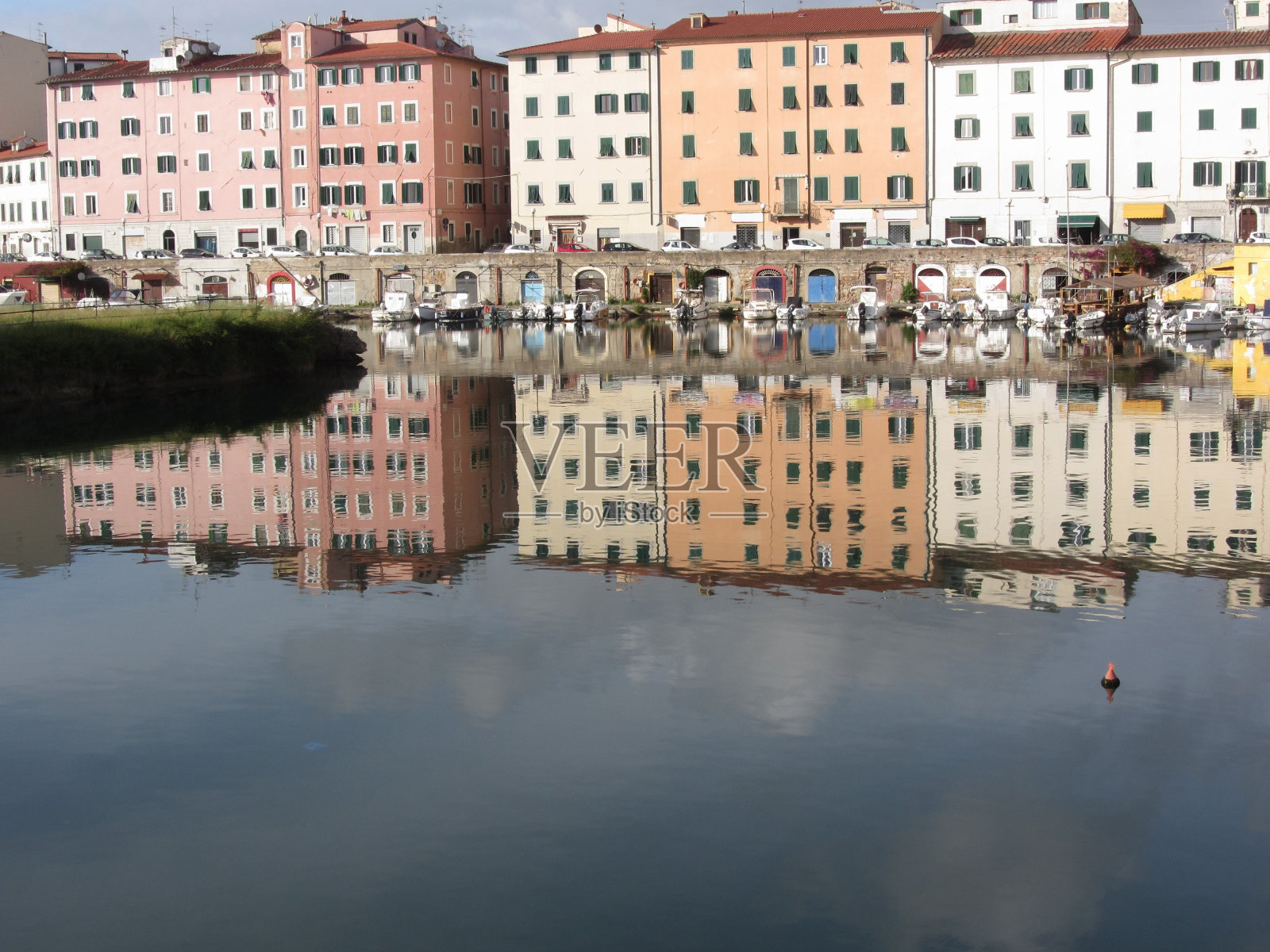 风景如画的古老住宅区附近的城市中心利沃诺。意大利托斯卡纳。房屋和船只倒映在平静的水面上照片摄影图片