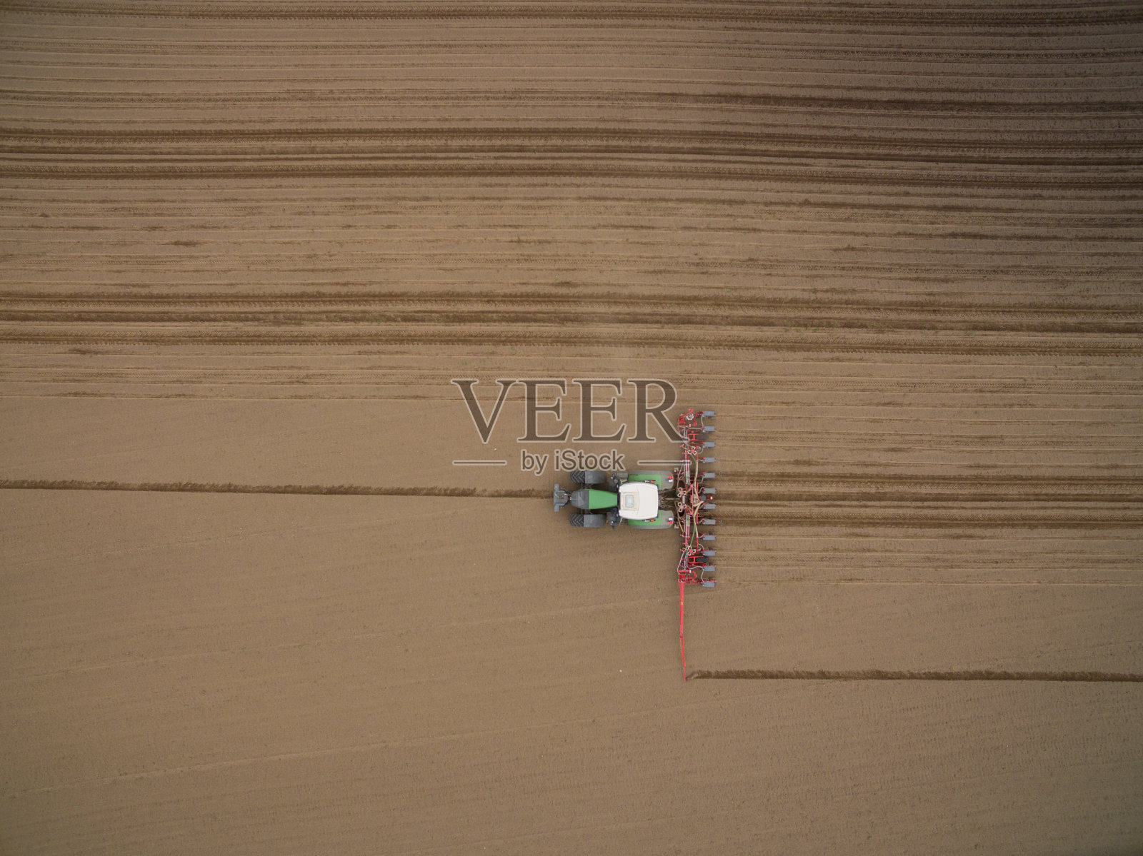 拖拉机-鸟瞰图拖拉机在耕作的田野在春天照片摄影图片