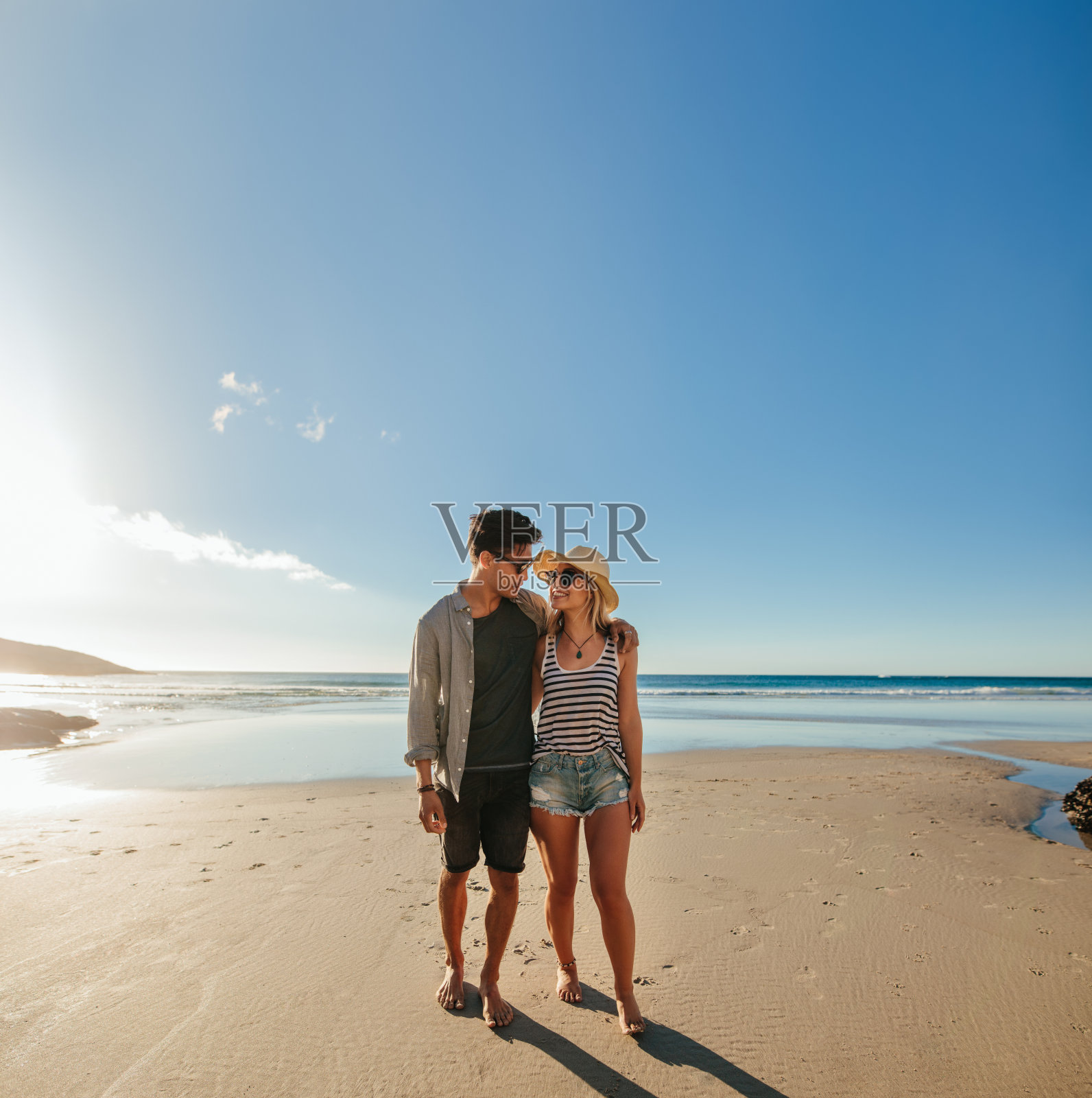 一对浪漫的年轻夫妇在海边散步照片摄影图片