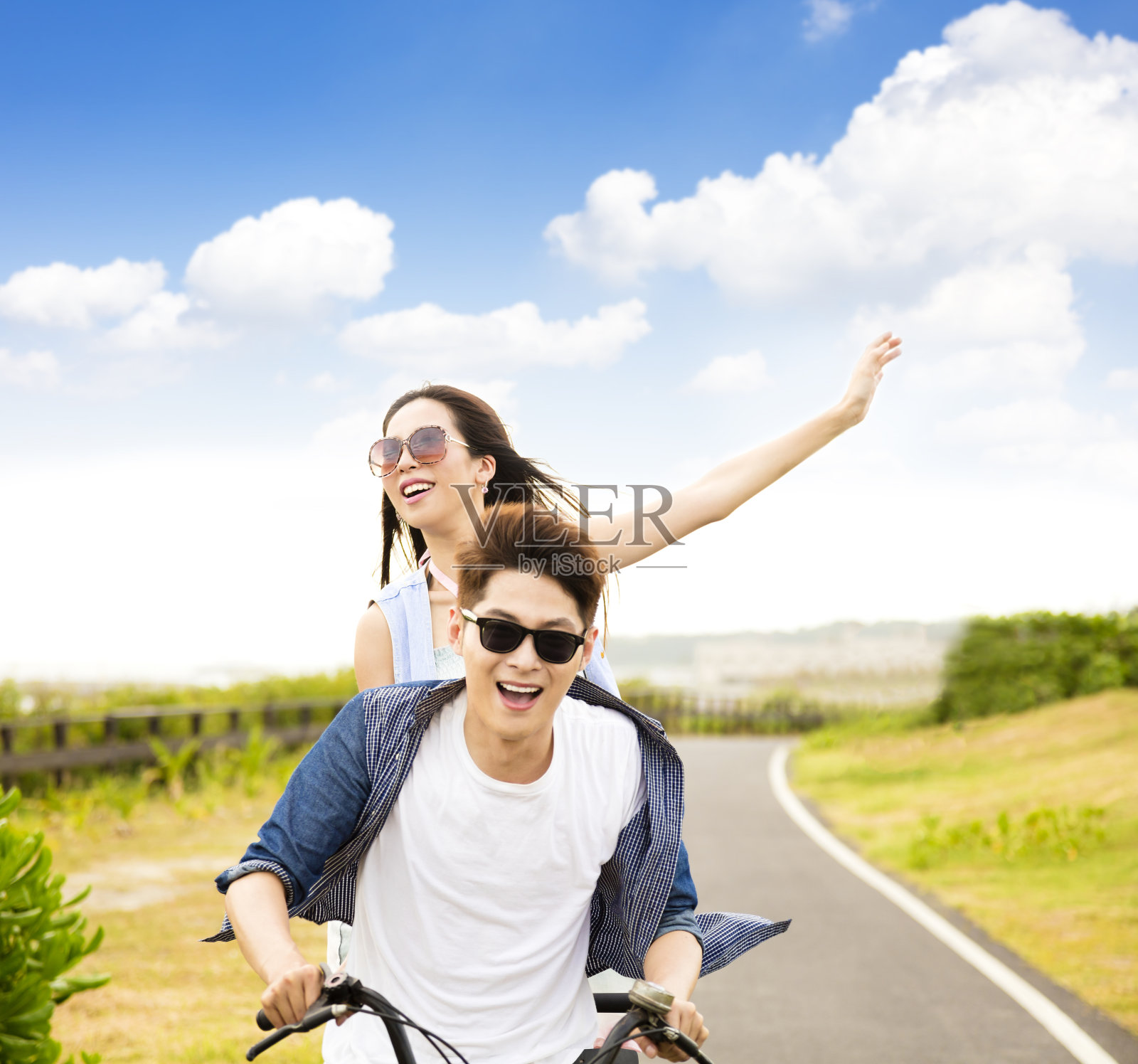 快乐的年轻夫妇在公园里骑自行车照片摄影图片