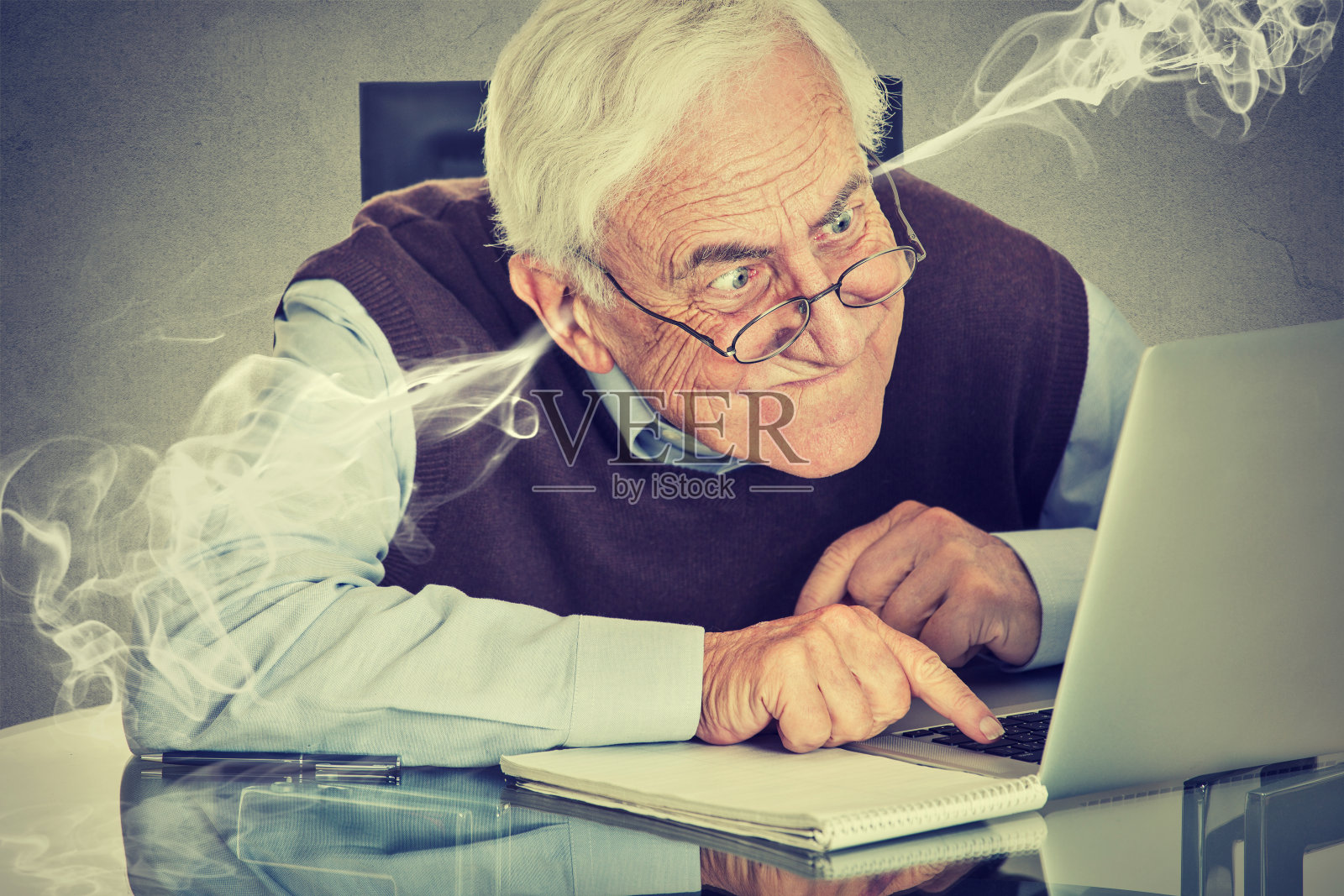 压力大的老人用电脑从耳朵里吹蒸汽照片摄影图片
