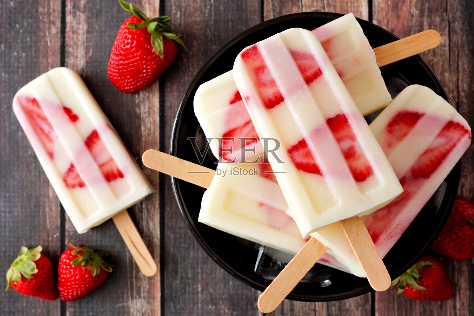 一碗黑木头上的草莓香草酸奶冰棒照片摄影图片