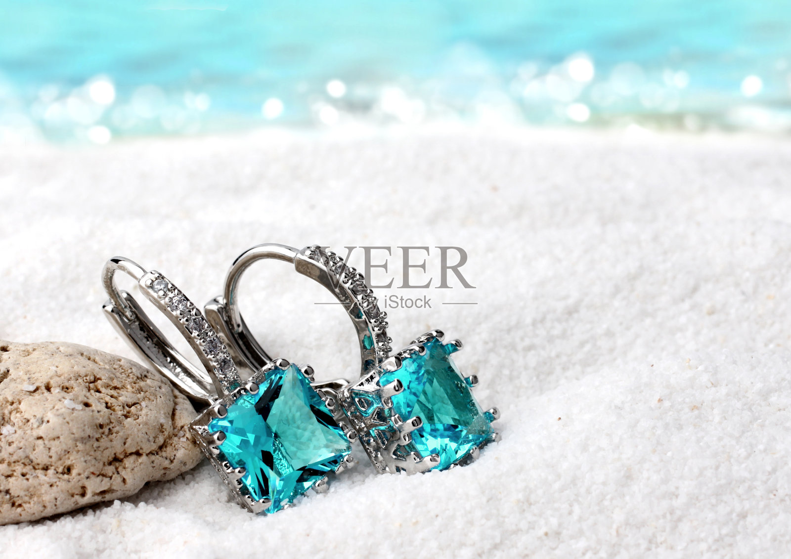珠宝耳环与海蓝宝石的沙滩背景，软焦点照片摄影图片