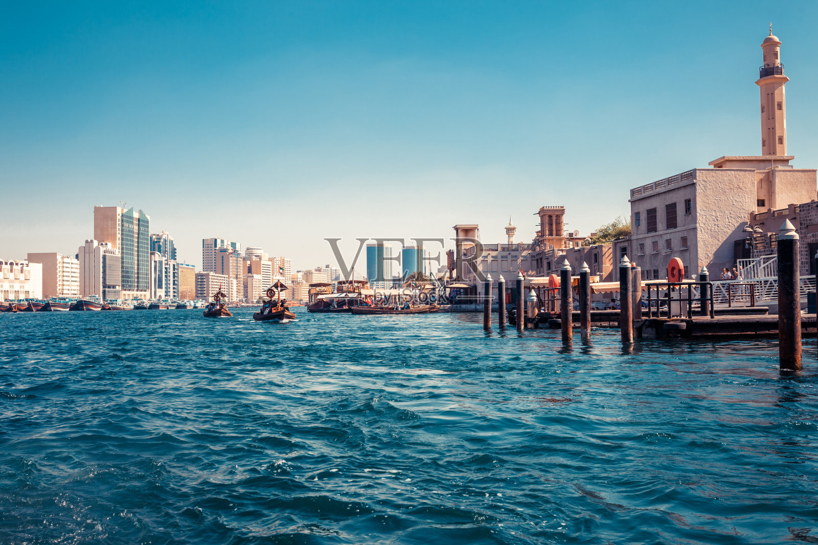 迪拜河的天际线与传统的船只和码头。阳光明媚的夏天的一天。阿联酋著名的旅游胜地。照片摄影图片