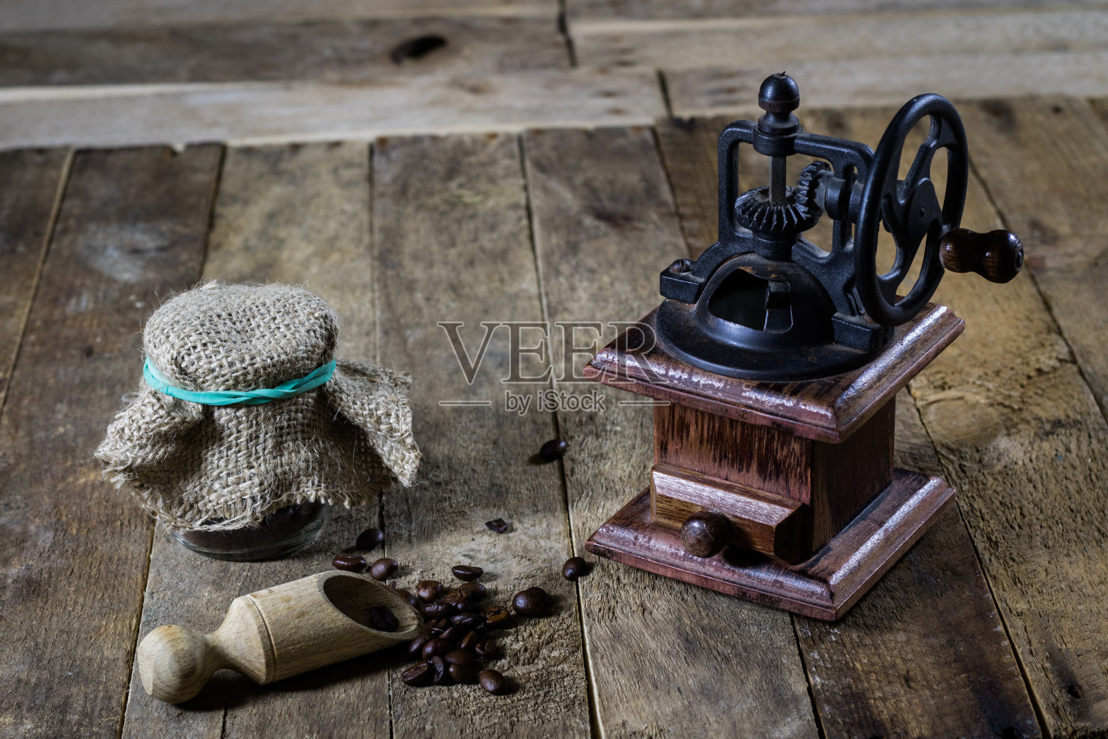 在旧木桌上研磨美味咖啡的老式时尚研磨机照片摄影图片