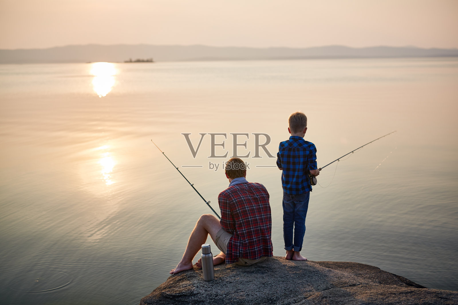 父亲和儿子在日落钓鱼照片摄影图片