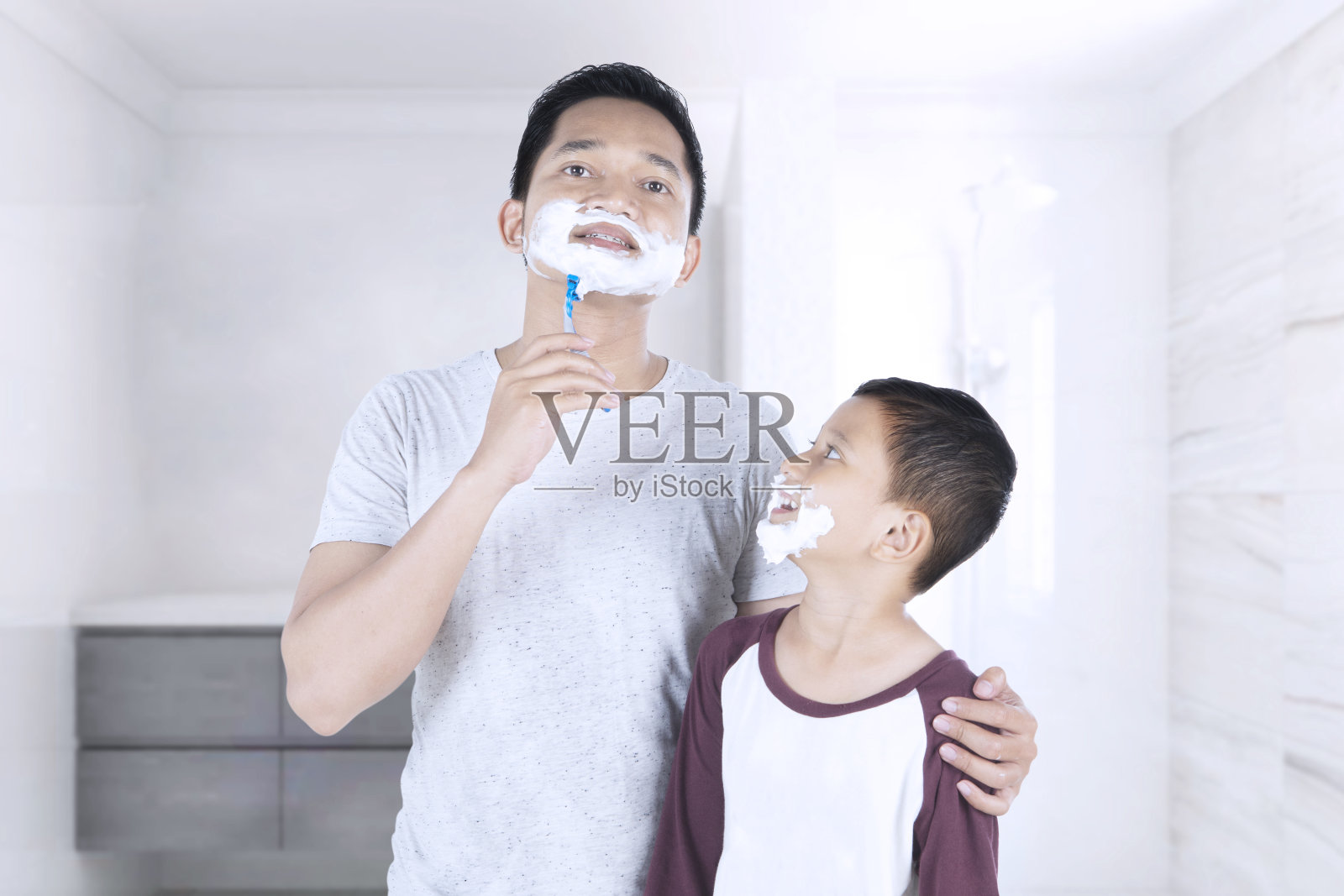 男人和他儿子带着剃须泡沫照片摄影图片