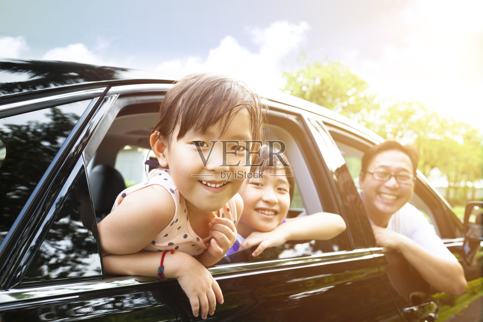快乐的小女孩和家人坐在车里照片摄影图片