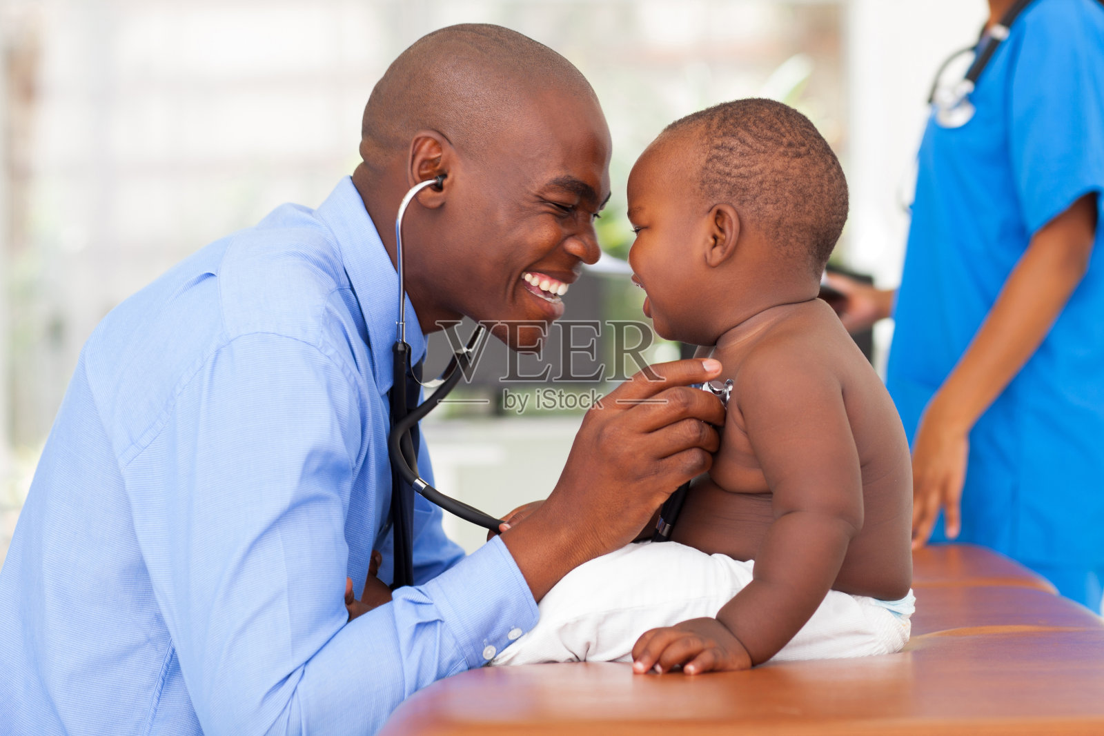 非洲男医生正在给男婴做检查照片摄影图片