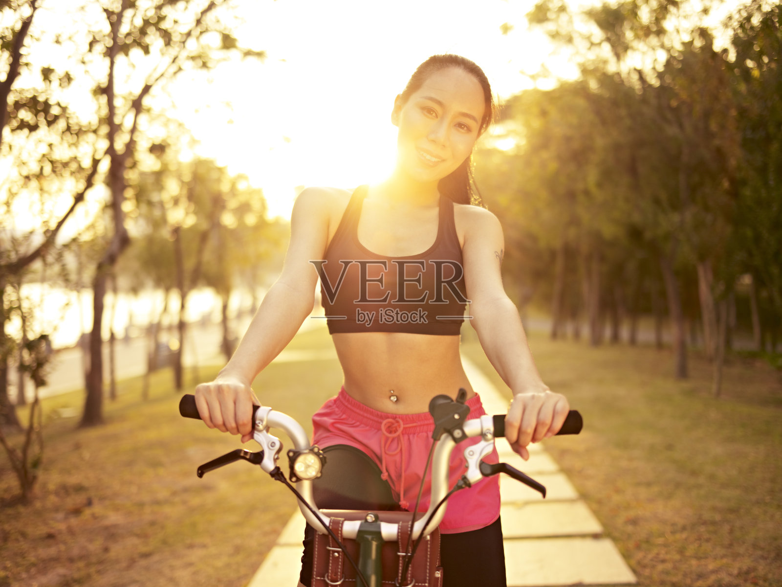 年轻的亚洲妇女在户外骑自行车日落照片摄影图片