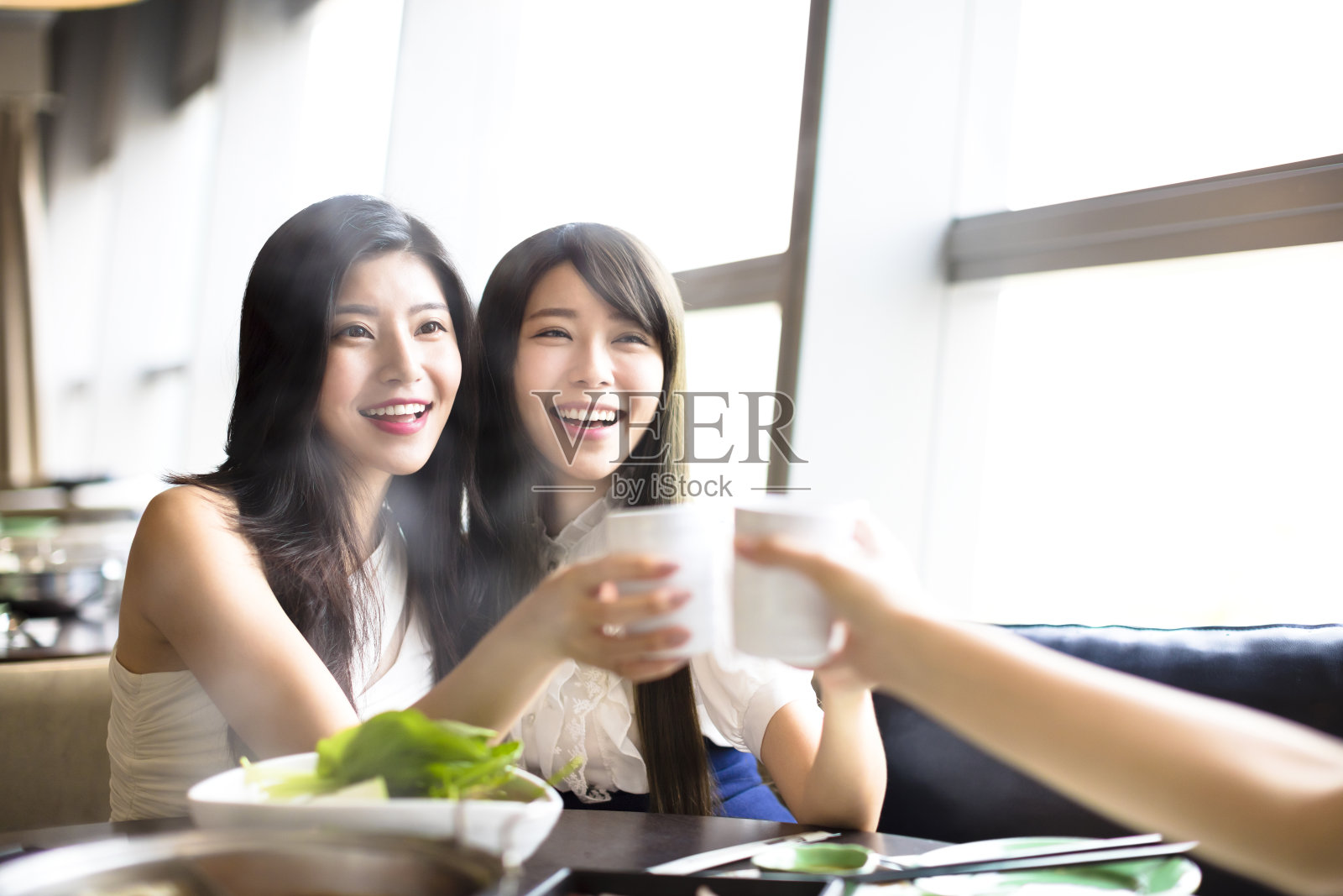 一群女性朋友在餐厅祝酒吃饭照片摄影图片