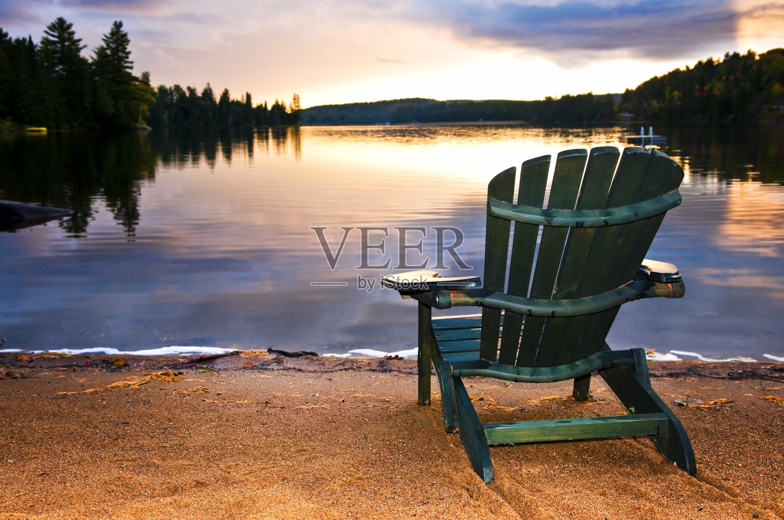 沙滩上日落时的木椅照片摄影图片