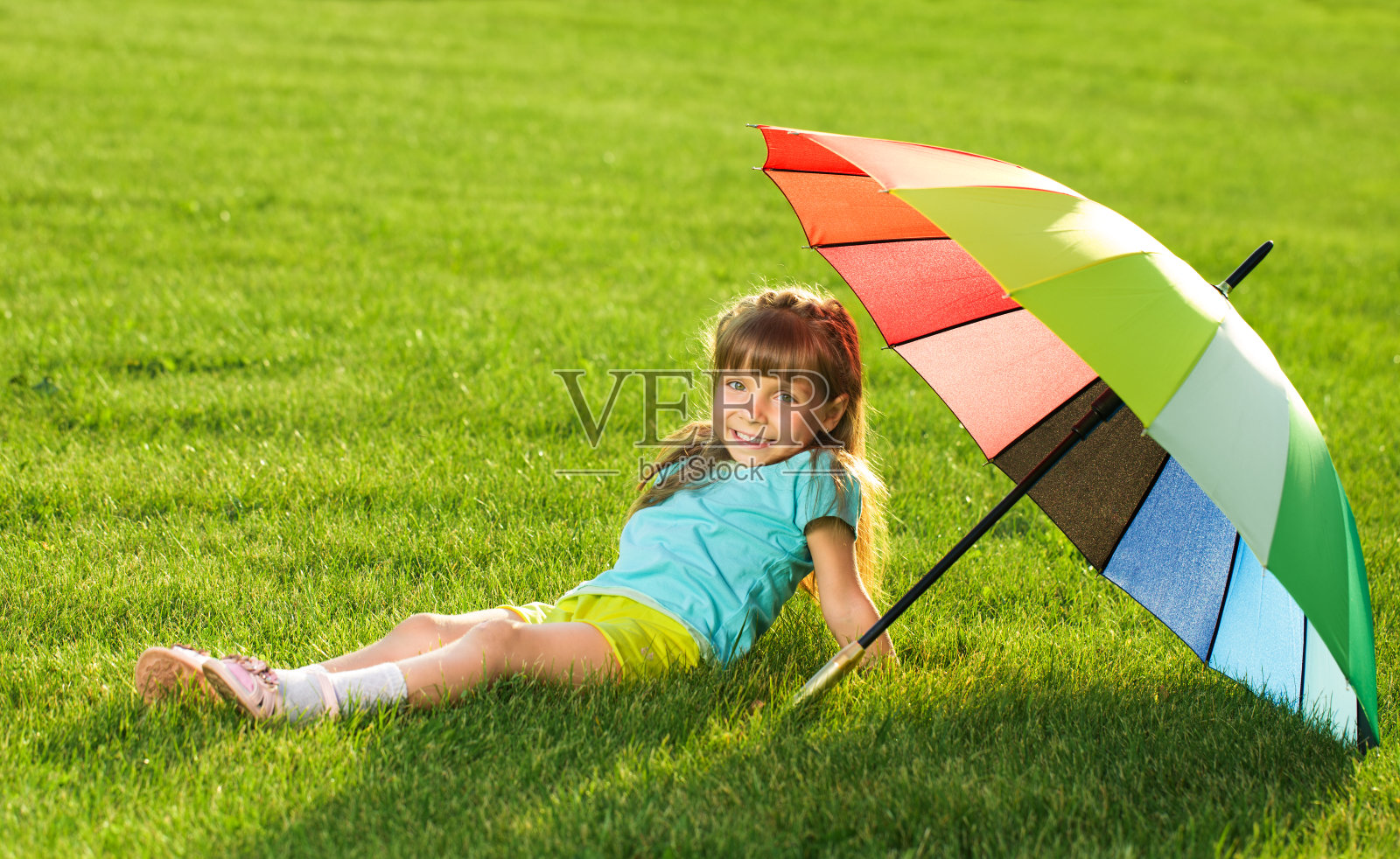 微笑的小女孩小孩在公园里拿着五颜六色的雨伞照片摄影图片