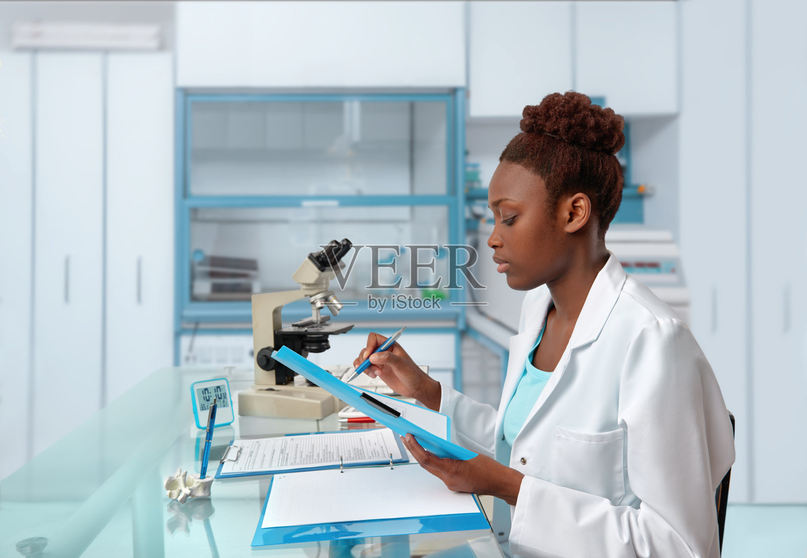 非裔美国生物学家在科学实验室或研究设施检查记录照片摄影图片